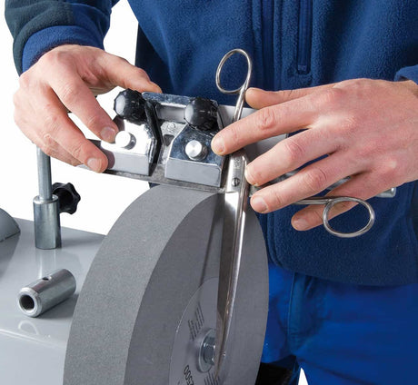 Supporto regolabile per forbici installato su affilatrice NTS 250 Vario, ideale per affilature professionali di lame dritte o curve.